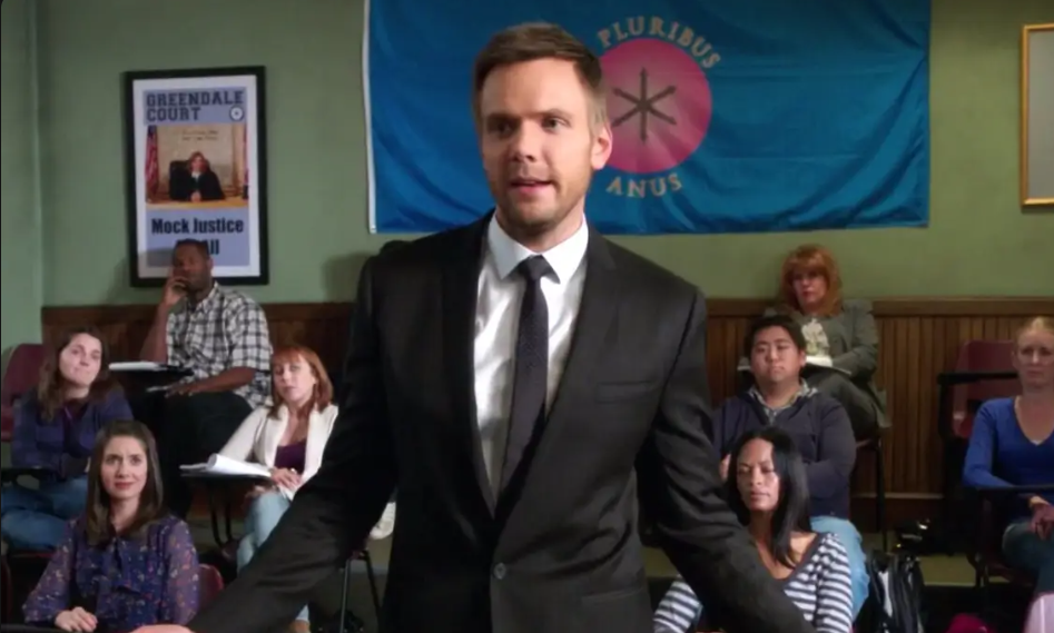 Jeff Winger can be seen in a good mood as he stands in front of a classroom. 