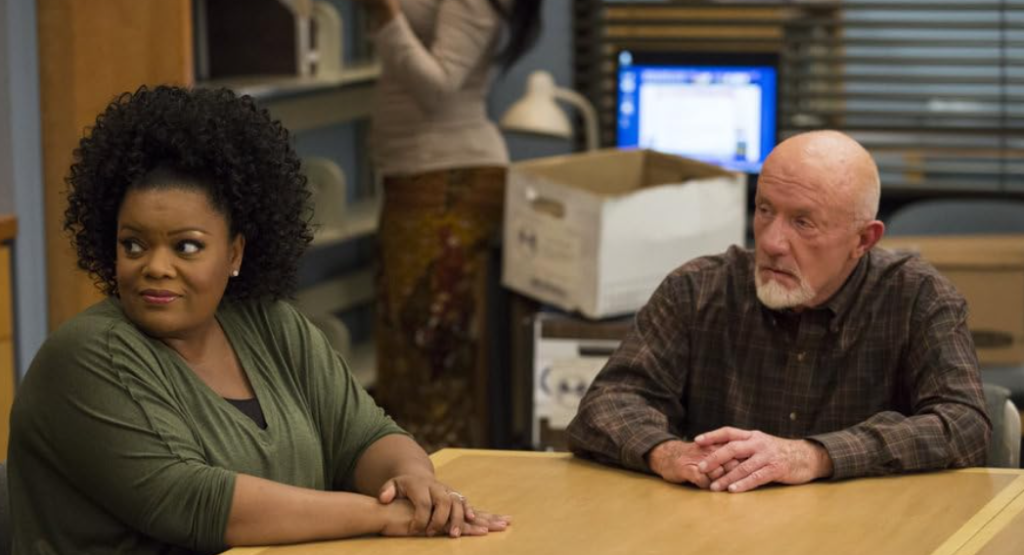 Jonathan Banks and Yvette Nicole Brown in a scene from Community, sharing a moment of conversation.