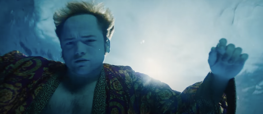 Taron Egerton as Elton John, diving deep in water. 