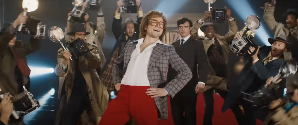 Taron Egerton dancing and posing as Elton John in Rocketman