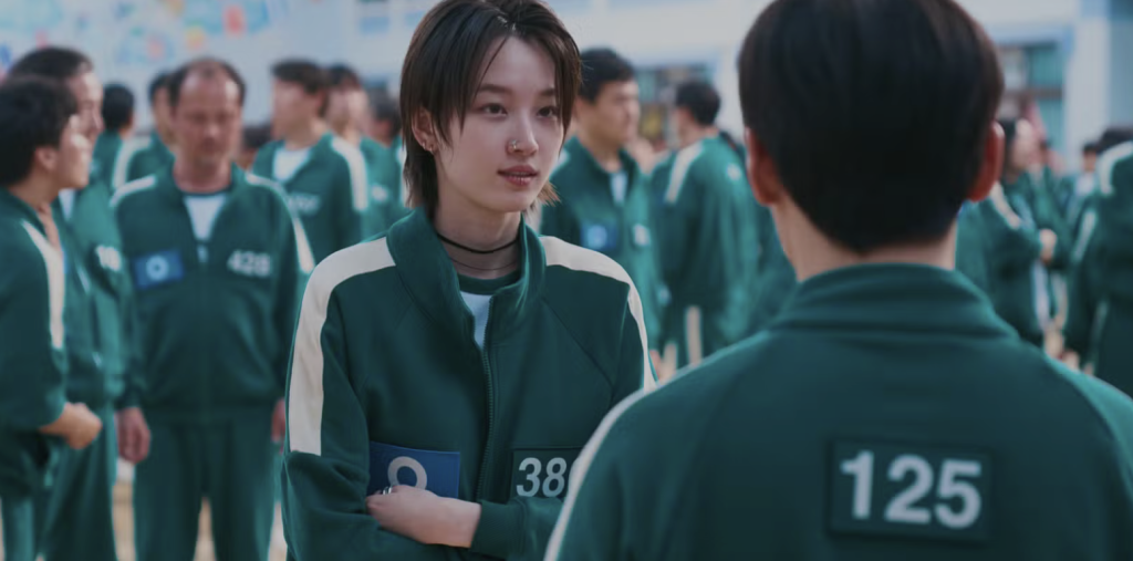 Won Ji-an as player 380 with short hair and the green squid game tracksuit. 