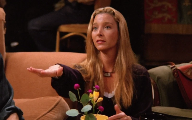 Lisa Kudrow as Phoebe Buffay in a FRIENDS episode extending her hand in a pledging action.