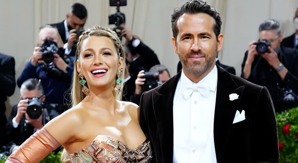Ryan Reynolds and Blake Lively on the Met Gala 2022 Red Carpet. They are both smiling and photographers are visible in the background.