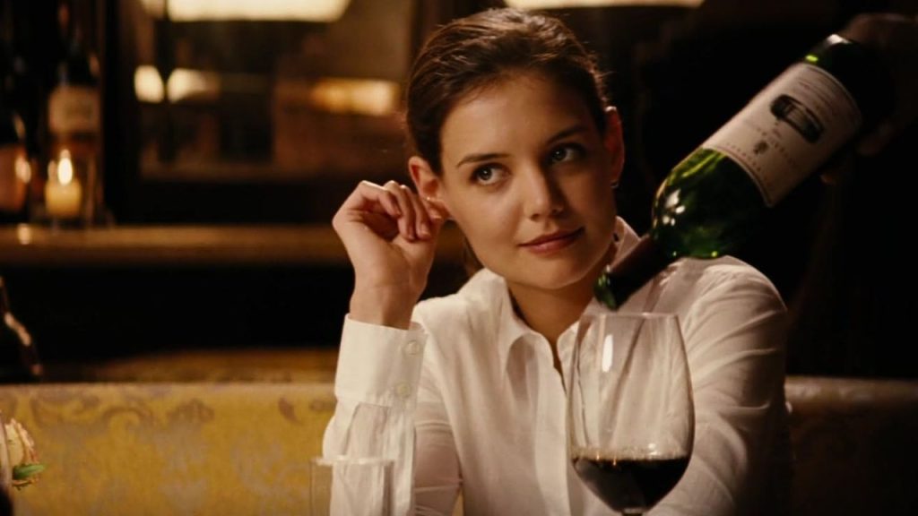 Katie Holmes sitting while wine is being poured in her glass