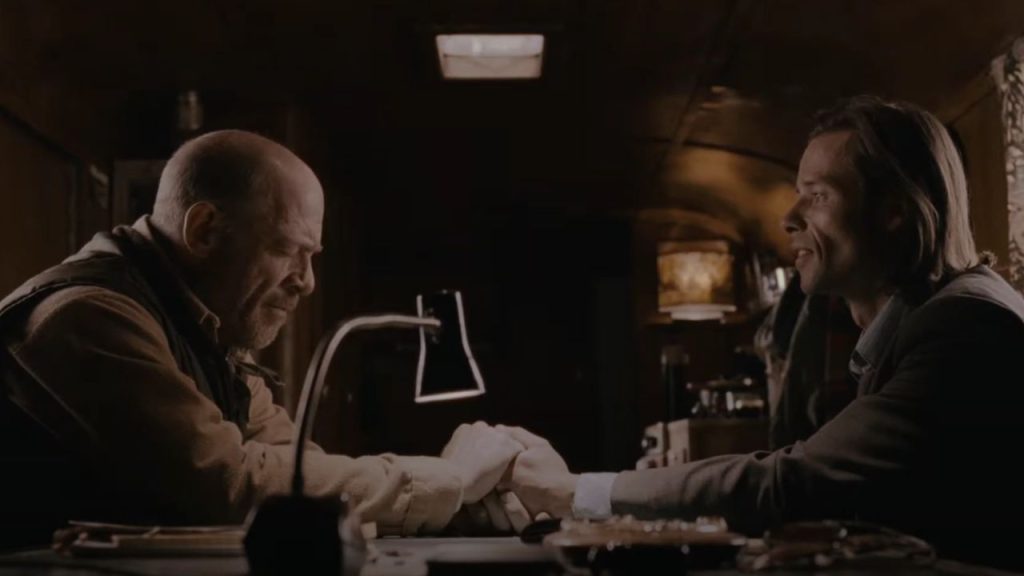 J.K. Simmons holding Guy Pearce's hands in First Snow 