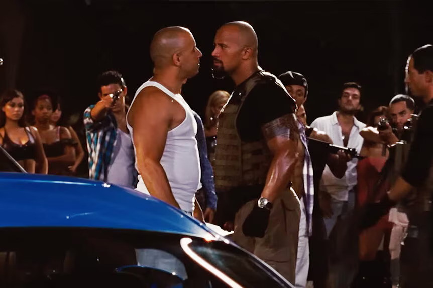 A nighttime confrontation scene from Fast & Furious 6 between Vin Diesel as Dominic "Dom" Toretto and Dwayne "The Rock" Johnson as Luke Hobbs.