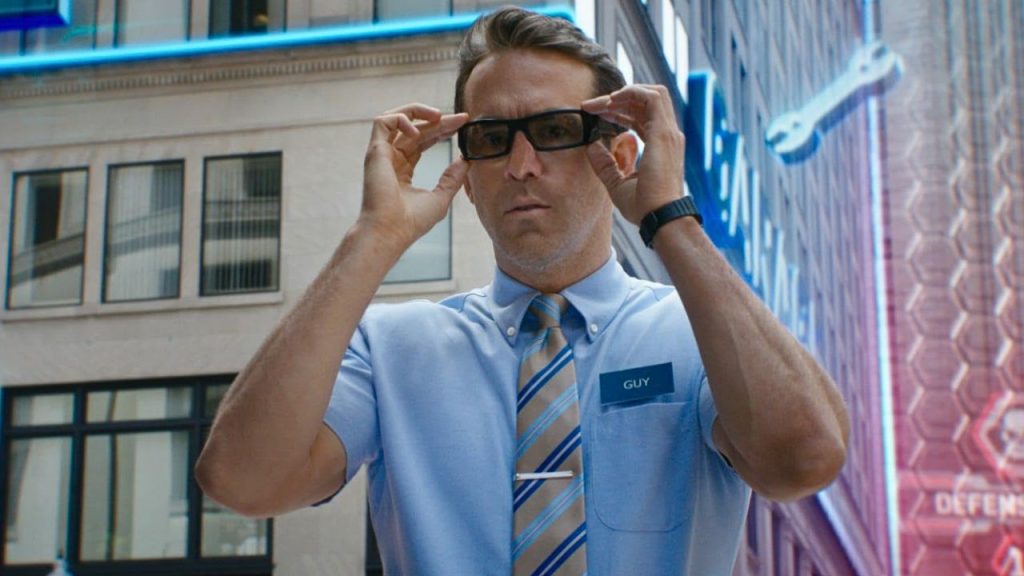 Ryan Reynolds holding his glasses in surprise in Free Guy