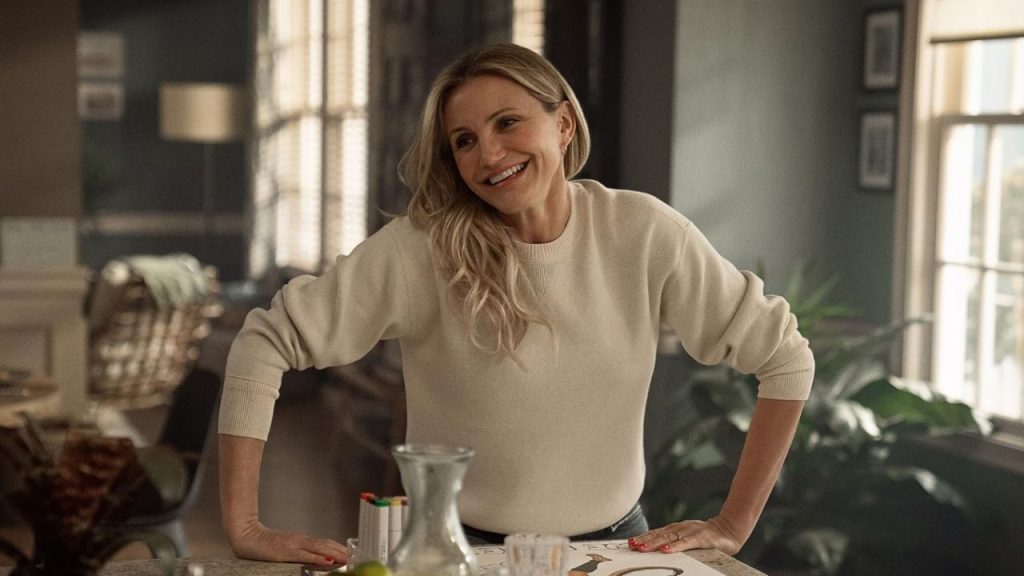 Cameron Diaz smiling while standing beside a table in Back in Action