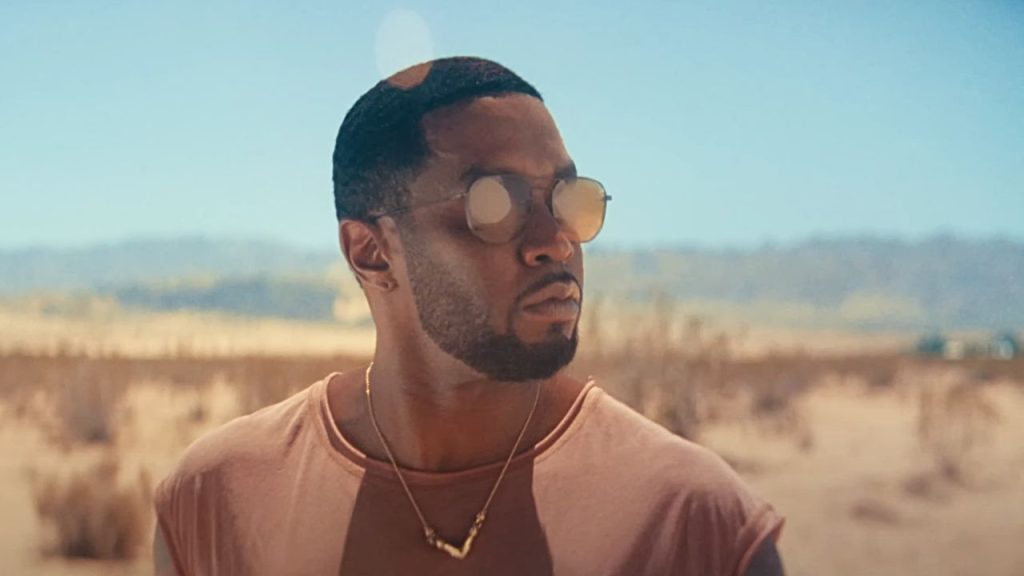 Sean P. Diddy Combs in a still from his Closer to God music video standing in a desert while wearing sunglasses.