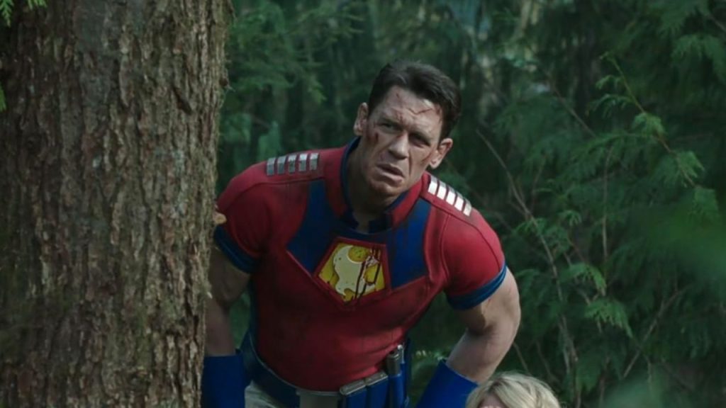 John Cena peeking at someone from behind a tree in Peacemaker