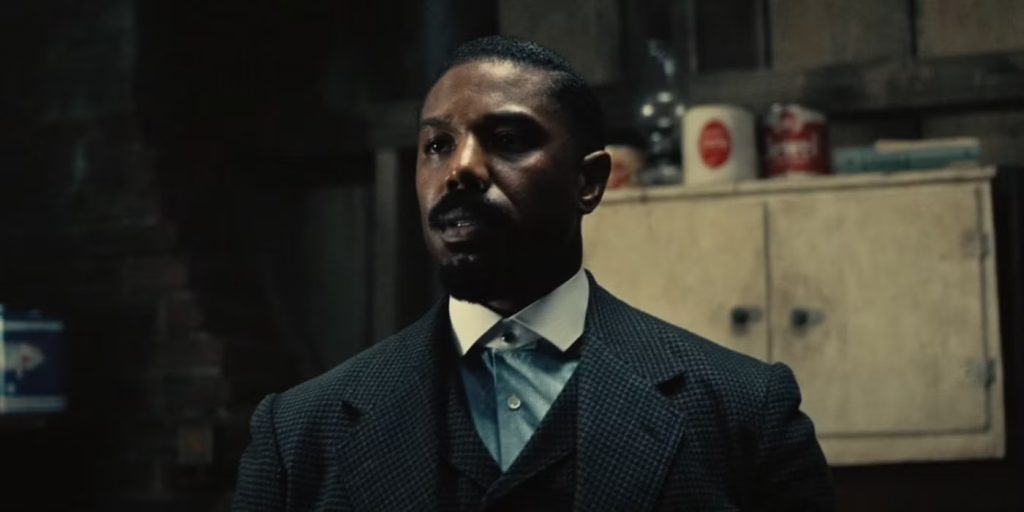 Michael B Jordan as Stash looking tense in a storeroom. 