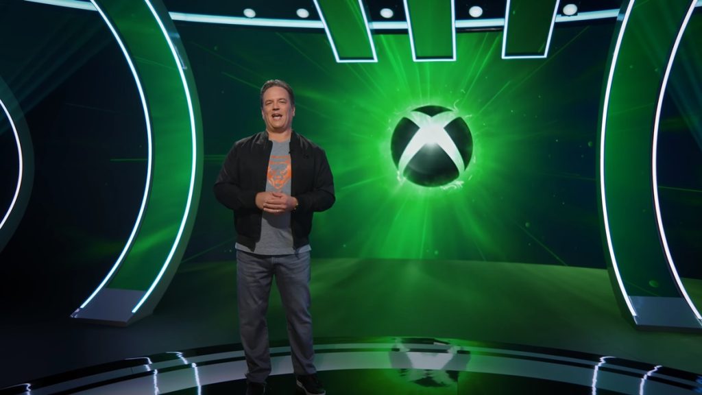 Image featuring Phil Spencer presenting a livestream with the Xbox logo appearing in the background.