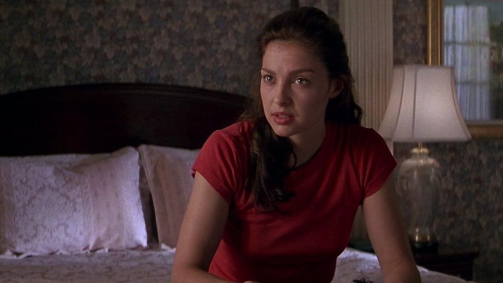 Ashley Judd talking to someone while sitting on bed in Kiss the Girls