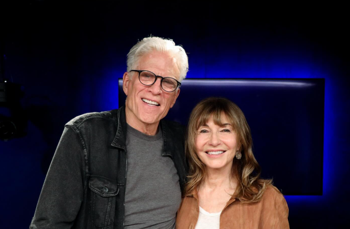 Ted Danson wearing a black posing with his wife Mary Steenburgen wearing a brown jacket