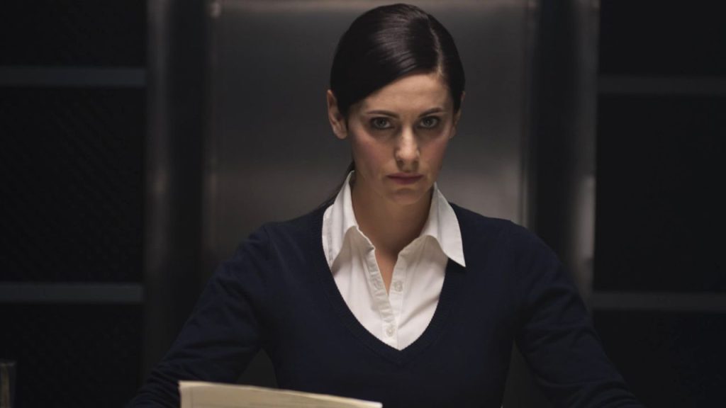 Erika Rosenbaum looking sternly while sitting in the movie The Fischer Case