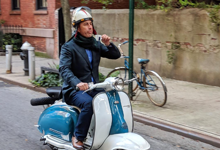 Comedian Jerry Seinfeld on a scooter.