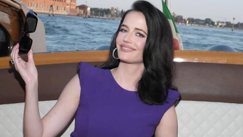 Eva Green holding her sunglasses and smiling