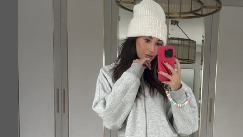 Michelle Keegan wearing white beanie and gray hoodie