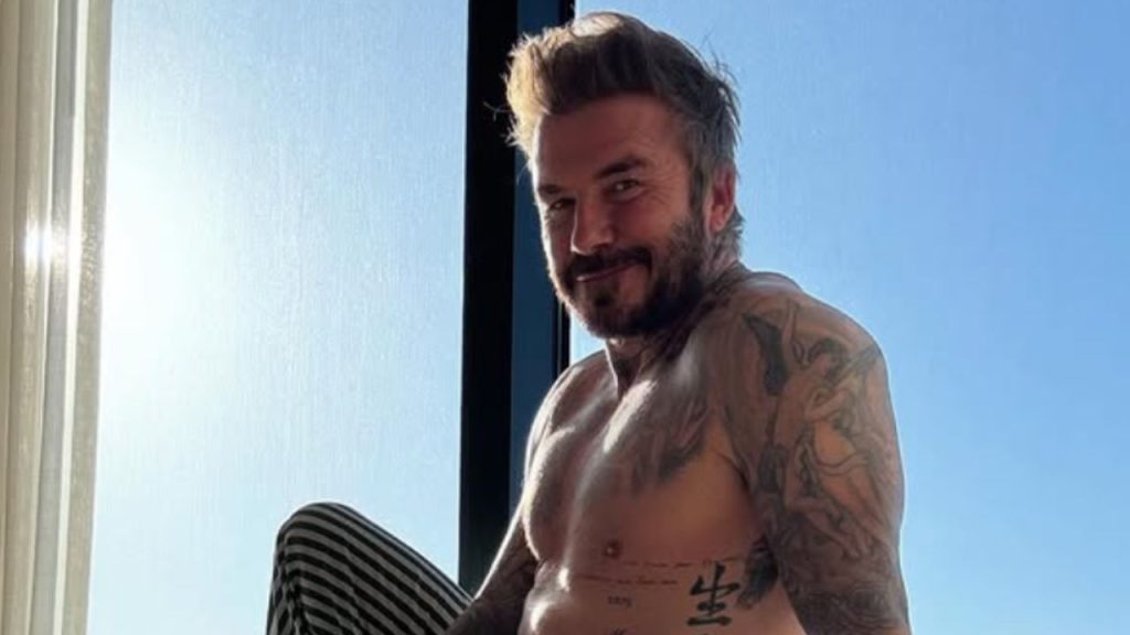 David Beckham sitting beside a window smiling