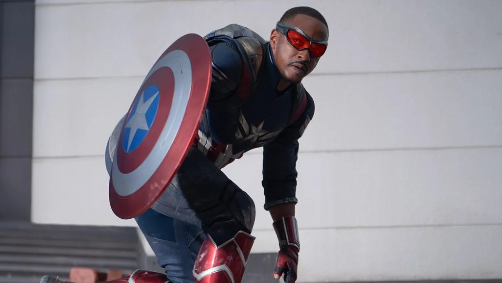 Anthony Mackie as captain America crouching and shield himself with Captain America's shield in Captain America: Brave New World 