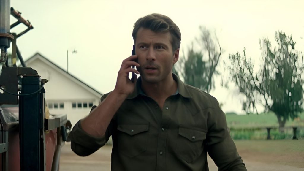 Glen Powell talking with someone on a call in Twisters