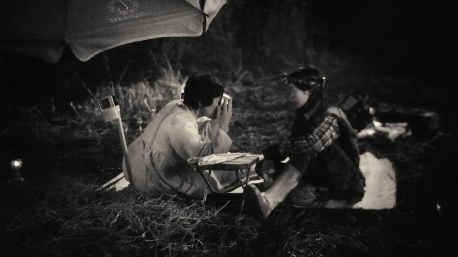 A black and white nighttime shot from 'Night Fishing' showing Lee Jung-hyun and Oh Kwang-rok sitting outdoors.