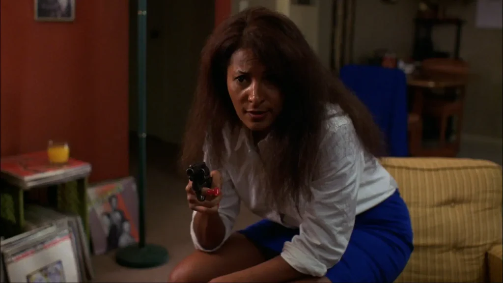 Pam Grier pointing a gun in a scene in Jackie Brown