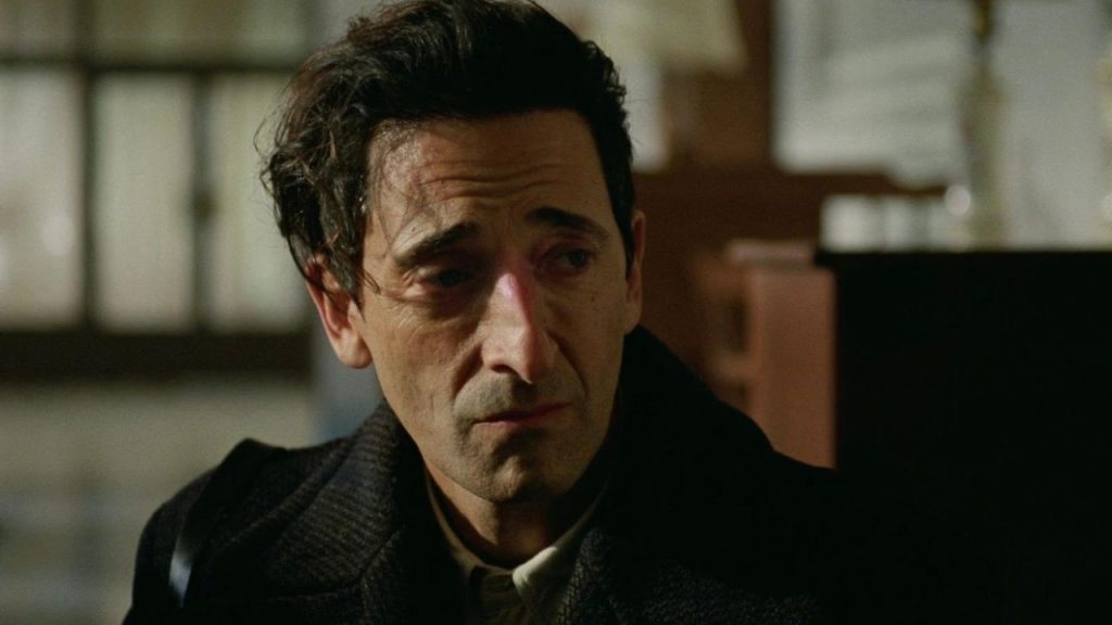 Adrien Brody looking sad in The Brutalist