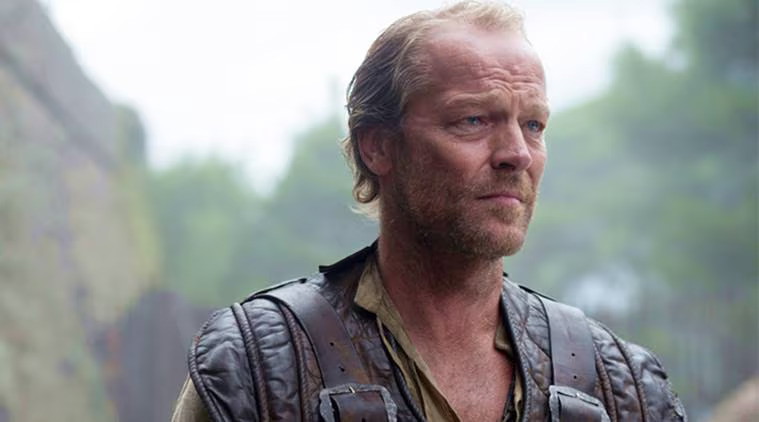 Jorah Mormont in weathered leather armor, looking off into the distance with a determined expression. The outdoor setting has a misty, green background.