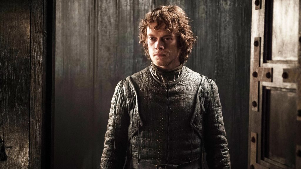 Theon Greyjoy standing in a dimly lit interior setting, wearing Greyjoy-style armor and clothing. His expression appears solemn.