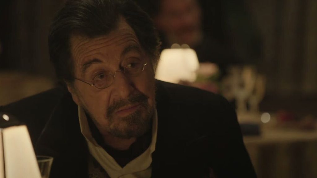 Al Pacino sitting in a restaurant, looking at someone in Modi: Three Days on the Wing of Madness