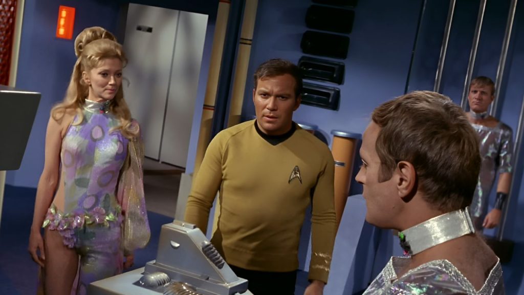 William Shatner, Kathie Browne, and Jason Evers standing together while looking at a device in Star Trek