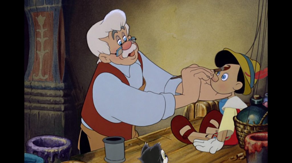 A still from the 1940 animated Disney film "Pinocchio" showing Geppetto painting or finishing Pinocchio's face.