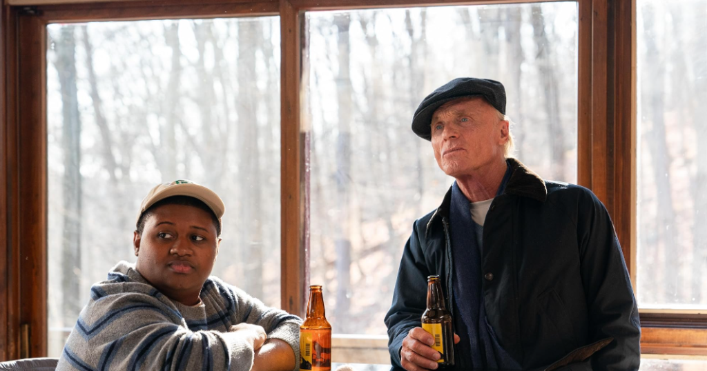 Ed Harris and Miles J. Harvey in a scene from Riff Raff, both dressed in casual attire.