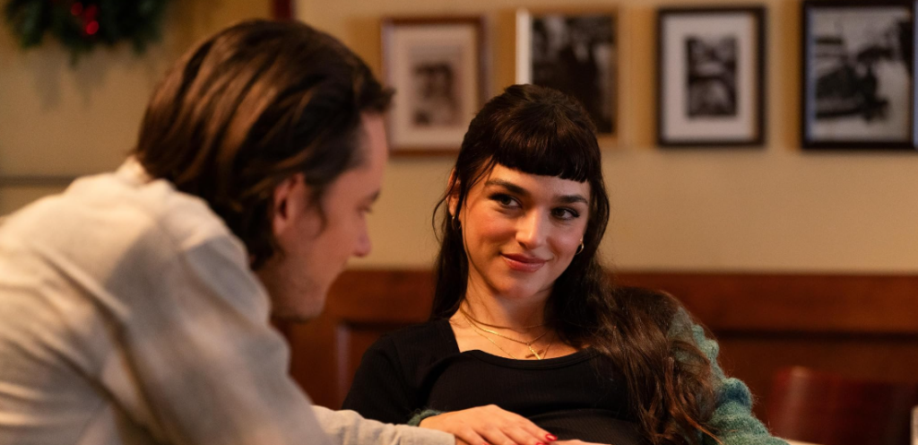  Emanuela Postacchini and Lewis Pullman smiling at each other, with Postacchini showing a bright smile.