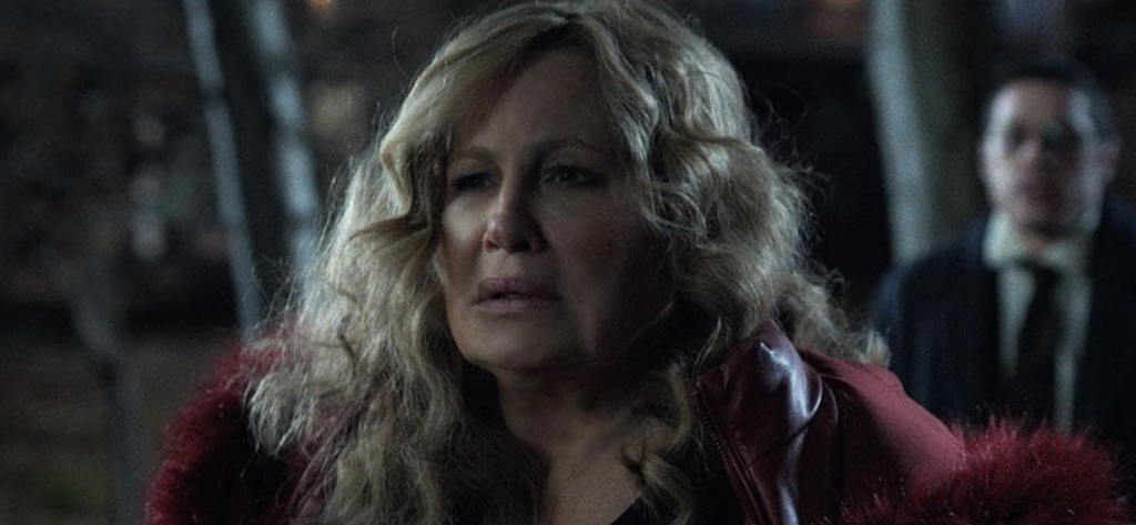 Jennifer Coolidge with a miserable expression, looking downcast and distressed in a scene from Riff Raff.