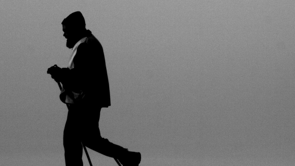 A black and white silhouette of a person walking.