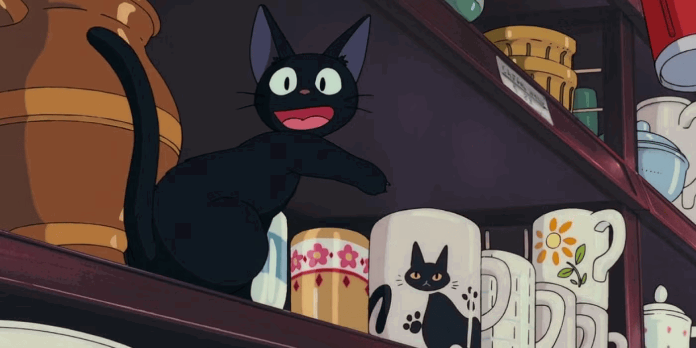 Jiji pointing at a cup with a black cat on it in Kiki's Delivery Service. 