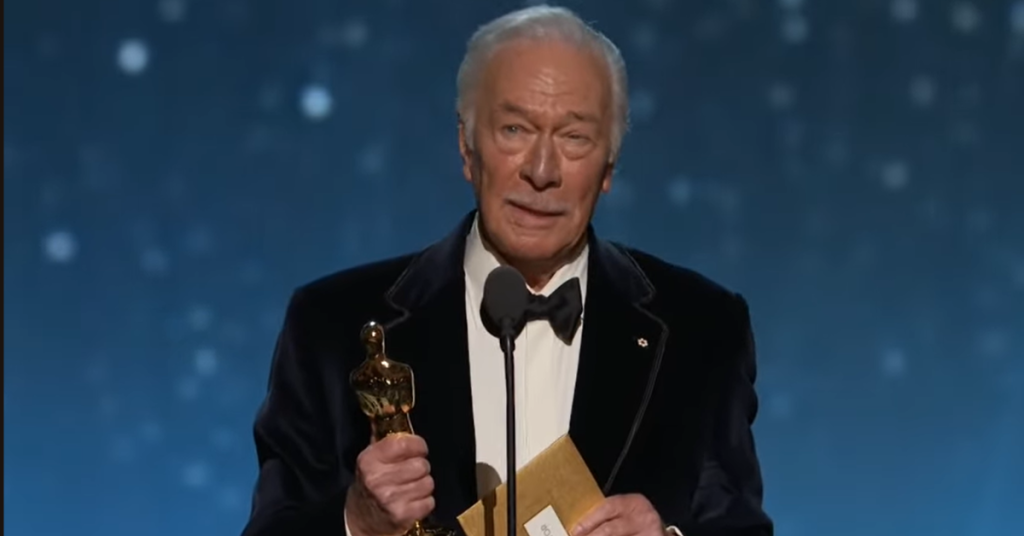 Christopher Plummer holding a Oscar that he won. 