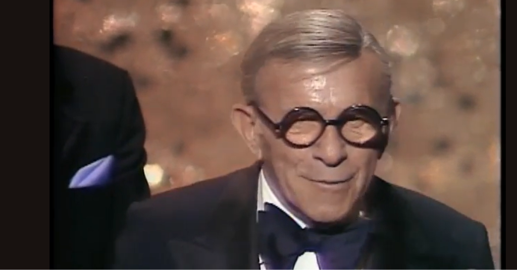 George Burns of stage after collecting his Oscar. 