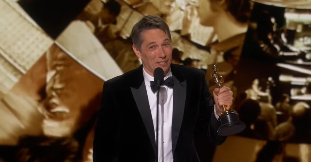 Sean Baker holding an Oscar. 