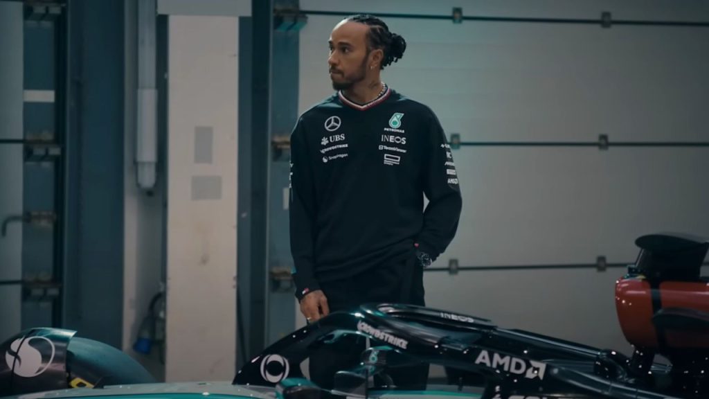 Lewis Hamilton standing and looking sideways in Formula 1: Drive to Survive