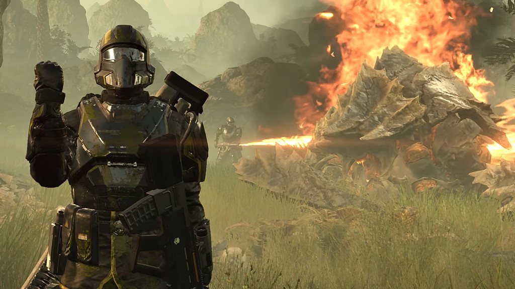 Helldivers 2 screenshot featuring a Helldiver saluting toward the camera while another burns down an enemy Charger in the background.