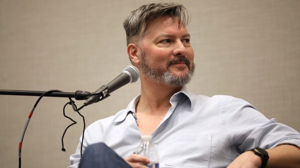 A close-up of David Hayter speaking at an event.