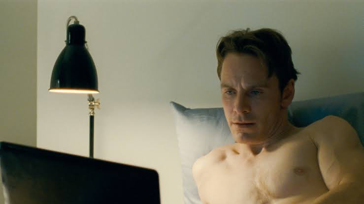 Michael Fassbender working on his laptop in his 2011 erotic drama Shame 