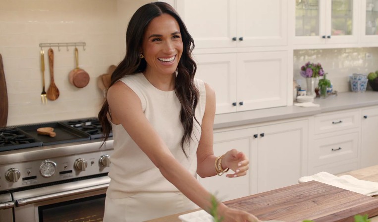 Meghan Markle laughing in the kitchen during a scene from With Love, Meghan.