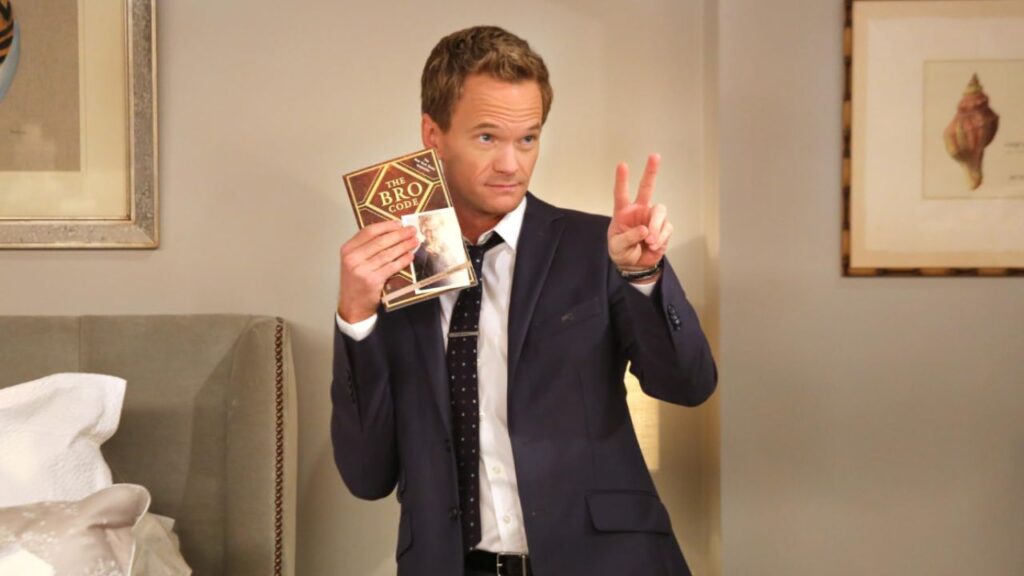 Neil Patrick Harris holding the Bro Code book in How I Met Your Mother