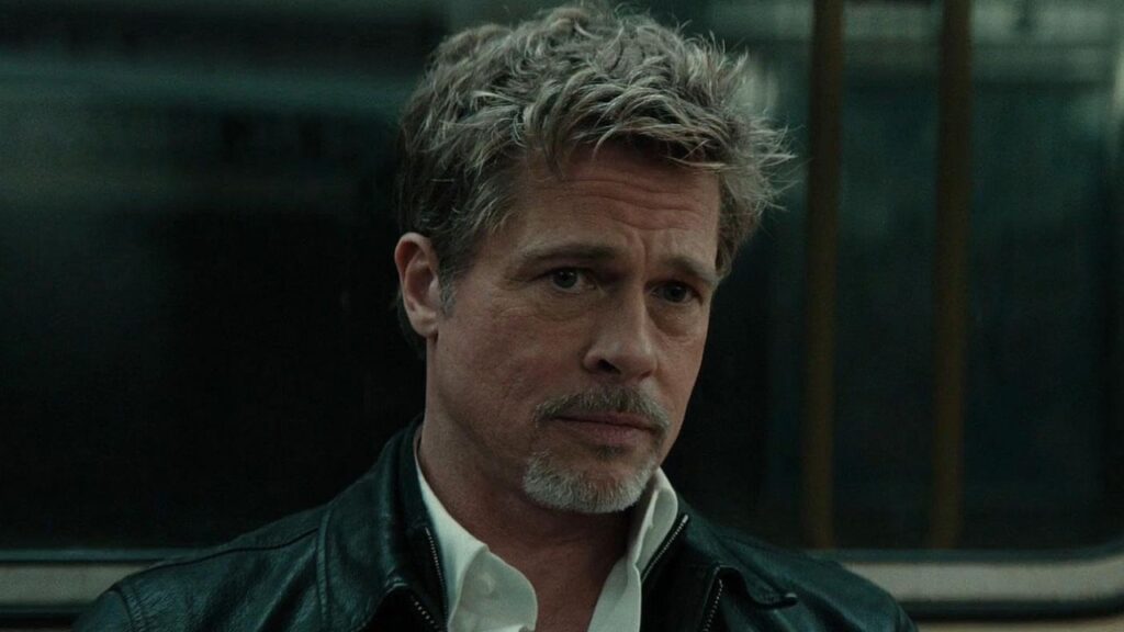 Brad Pitt looking worried while sitting in a train in Wolfs