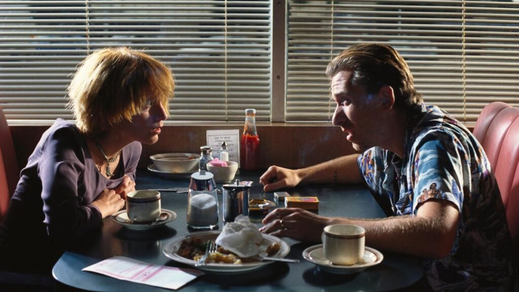 Tim Roth and Amanda Plummer talking to each other at a restaurant in Pulp Fiction