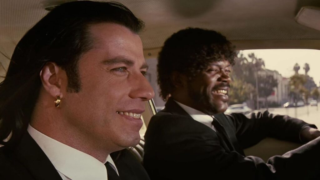 Samuel L. Jackson and John Travolta smiling while driving in Pulp Fiction